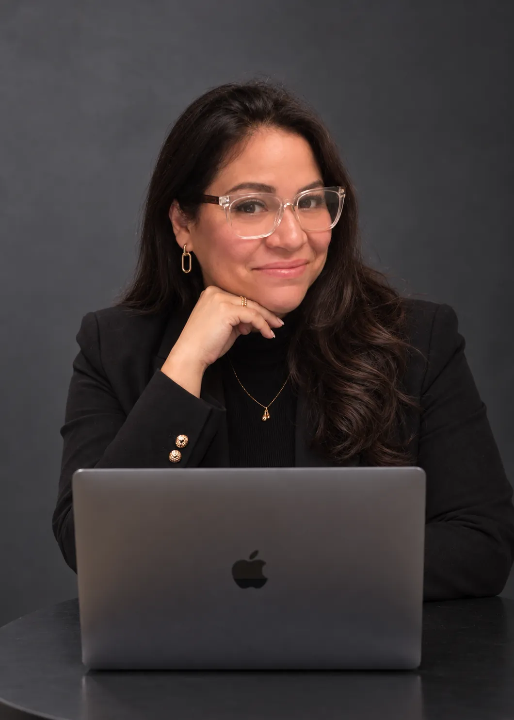Ana Casalegno con lentes, sonriendo detrás de su portátil