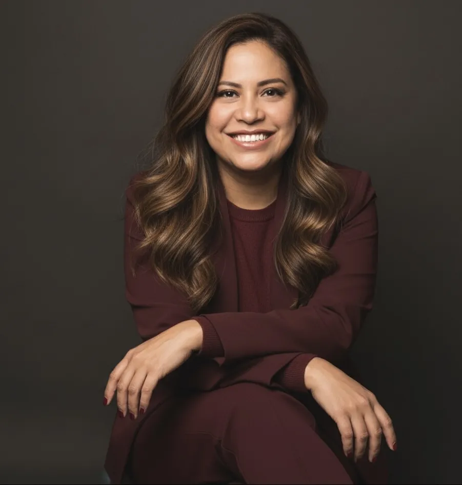 Ana sonriendo con traje color vino